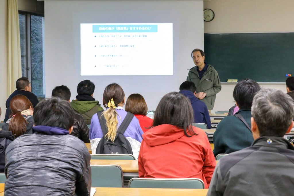 「はんのう森林みらい塾」の方々に、自由の森学園の脱炭素の取り組みについて講義をしている様子。