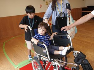 Image 8: Parents and children experiencing a wheelchair during the Autumn Exhibition.