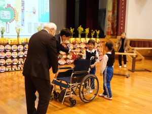 Image 9: Children presenting the seventh donated wheelchair.