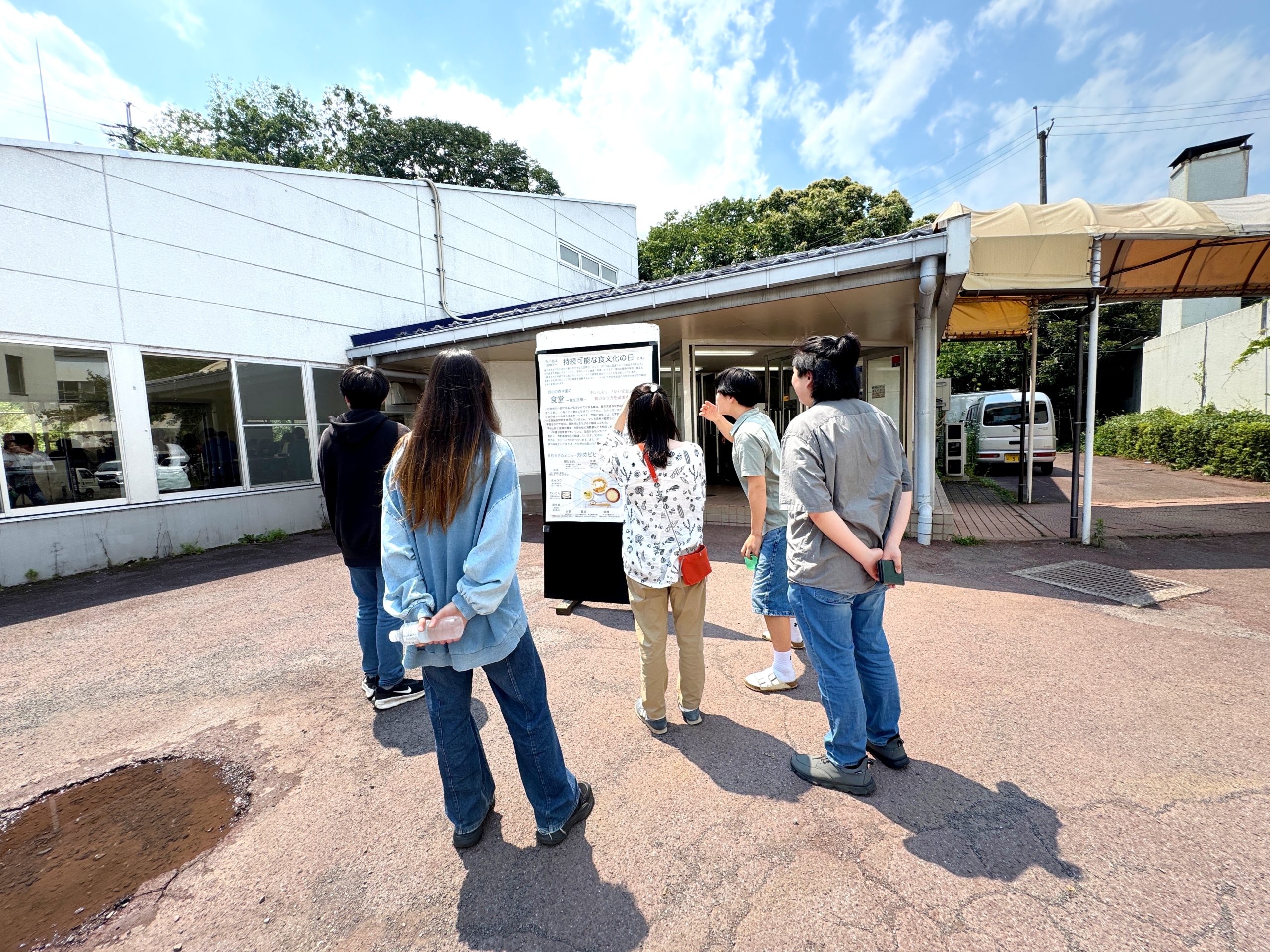 持続可能な食生活の日のポスターを見る生徒たち